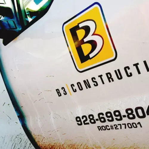 b3construction A close-up of a white truck door with the B3 Construction logo, phone number 928-699-8046, and license number ROC#277001. The truck has dirt marks and an F-250 Super Duty badge is visible.